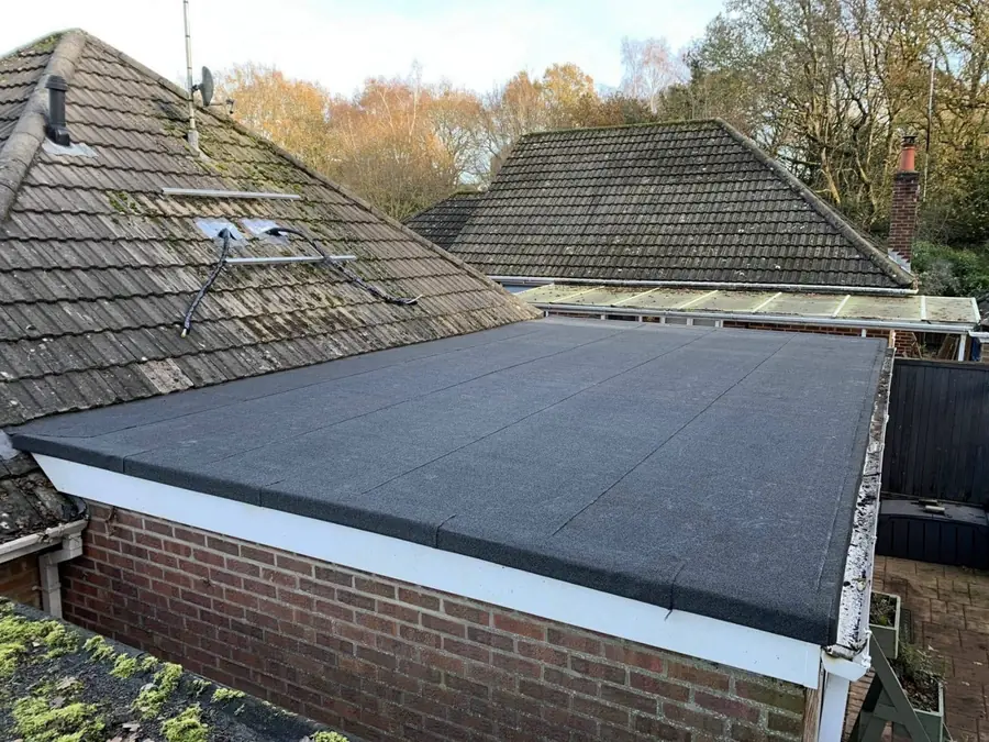 New felt flat roof on a brick extension beside an older tiled roof
